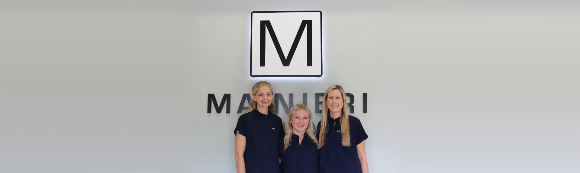 a group of women standing next to each other in front of a sign